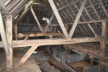 <p>Gebintenstructuur van de schuur gezien vanaf de hilde. De rondhouten daksporen en de pannendekking zijn latere vernieuwingen. </p>
